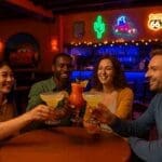 Friends enjoying cocktails and neon lights at Rio Grande Bar, Disney Hotel Santa Fe, Disneyland Paris
