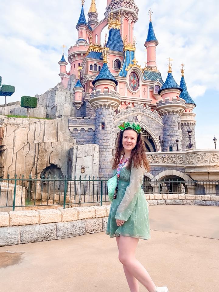 Tiana Disneybound at Disneyland Paris Guest Disneybounding as Princess Tiana in a green dress by Sleeping Beauty Castle at Disneyland Paris