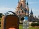 Packed lunch with apple, sandwich, and water bottle on a bench in front of Sleeping Beauty Castle at Disneyland Paris
