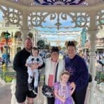 family photo in the gazebo with sleeping beauty castle in background