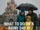 Family in raincoats at Disneyland Paris with castle in background during rainy weather, promoting the 2025 rainy day guide
