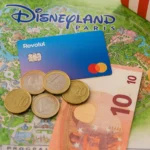 Revolut card, euro coins and notes on a Disneyland Paris map with a Mickey waffle – guide to paying with card or cash