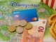 Revolut card, euro coins and notes on a Disneyland Paris map with a Mickey waffle – guide to paying with card or cash