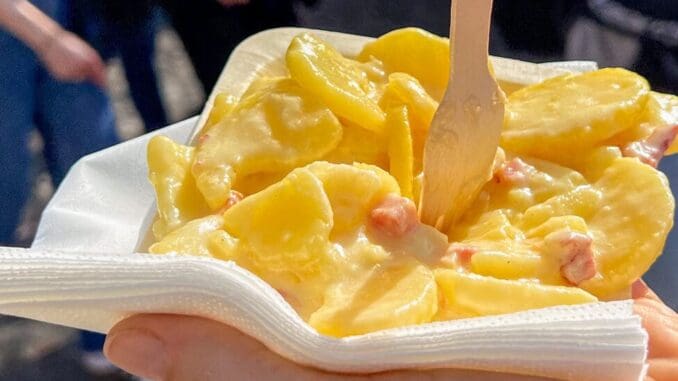 Tartiflette au Reblochon at Disneyland Paris food market stall featuring potatoes bacon and melted cheese
